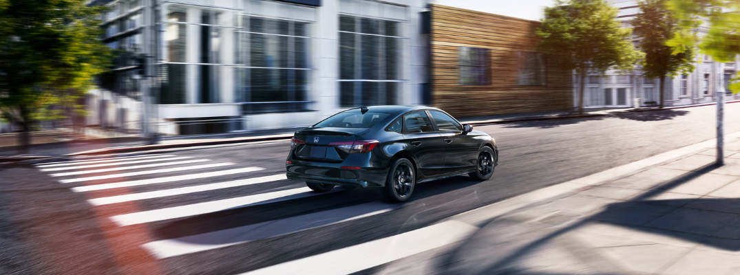A 2026 Honda Civic Hybrid driving down a city street